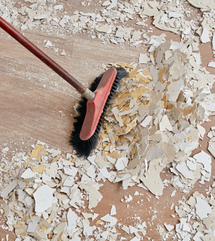 Builder sweeping the floor after renovation